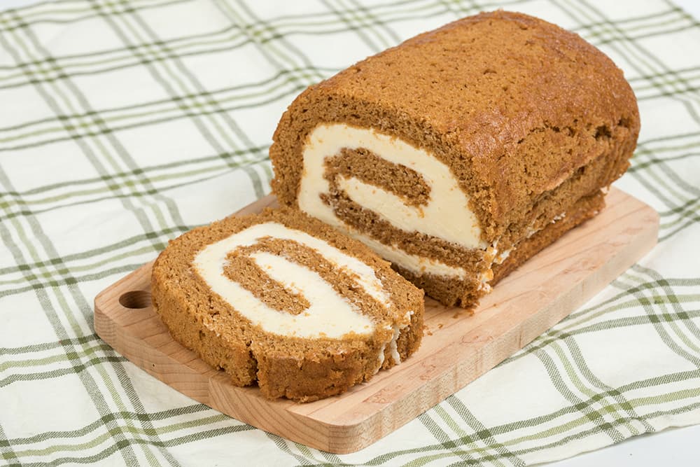 Handcrafted Amish-style pumpkin cake roll with moist pumpkin layers and creamy filling, lightly dusted with powdered sugar, perfect for Kitchen & Food, Snacks and Sweets, and USA Made collections.