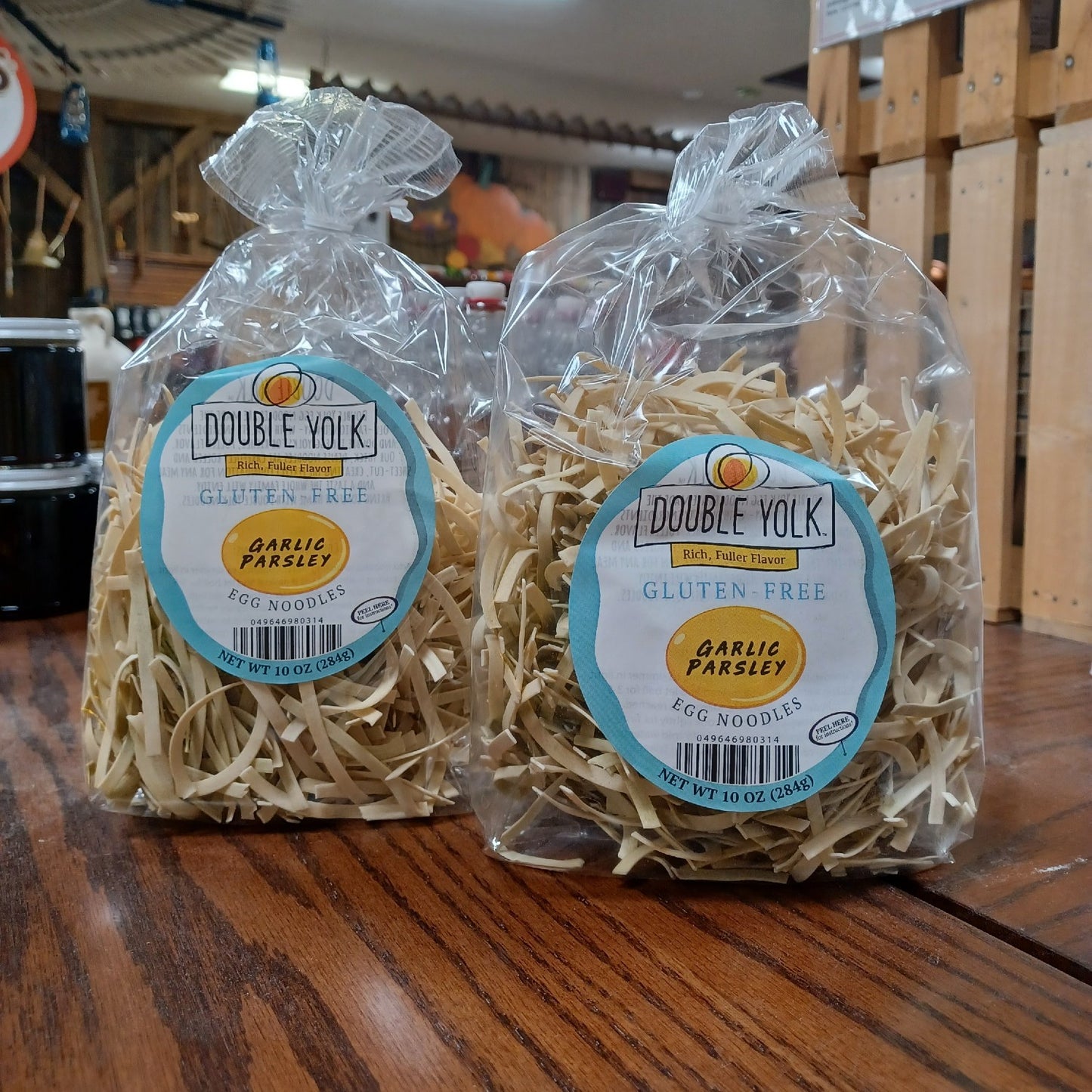 Two clear plastic bags containing gluten-free egg noodles with garlic parsley flavor, each with a light beige homestyle texture, part of Kitchen & Food, Gluten Free, Pantry, USA Made, and Best Sellers collections.
