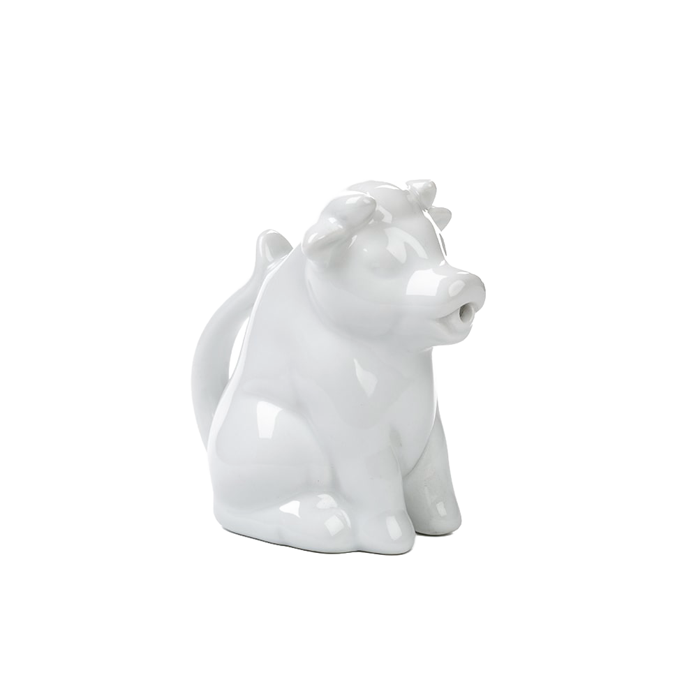 Glossy white porcelain creamer shaped like a sitting cow with a tail handle and pouring-spout mouth, handcrafted and perfect for Kitchen & Food, Brewing Coffee and Tea, Dinnerware collections.
