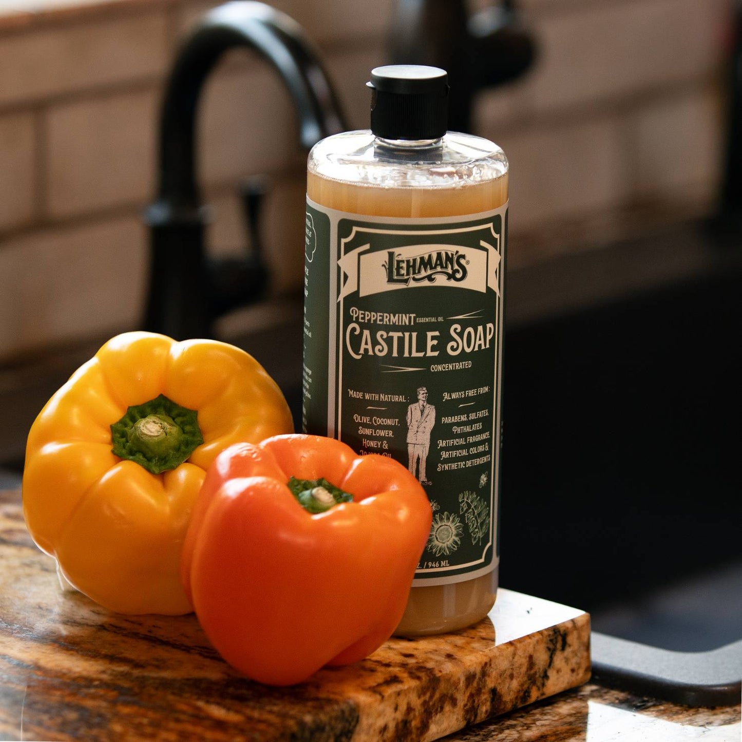 Handcrafted peppermint scented concentrated castile soap bottle displayed on kitchen counter with yellow and orange bell peppers, highlighting USA made natural soap in Health & Wellness and Grooming collections.