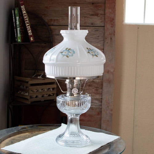 Handcrafted white glass oil lamp with soft blue floral design on the shade, featuring clear glass base, ideal for Lamps & Lighting, Parts and Accessories, Lamp Shades, and Best Sellers collections.