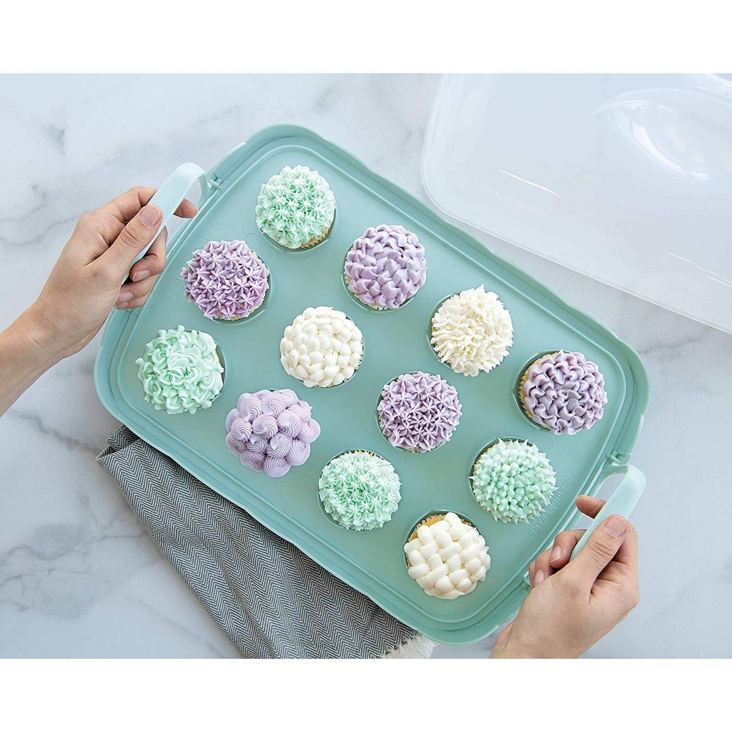 A reversible cake and cupcake carrier with scalloped red edging and snap-lock handles holds 12 pastel-decorated cupcakes on a light blue tray, made in USA for Kitchen & Food and Baking Supplies collections.
