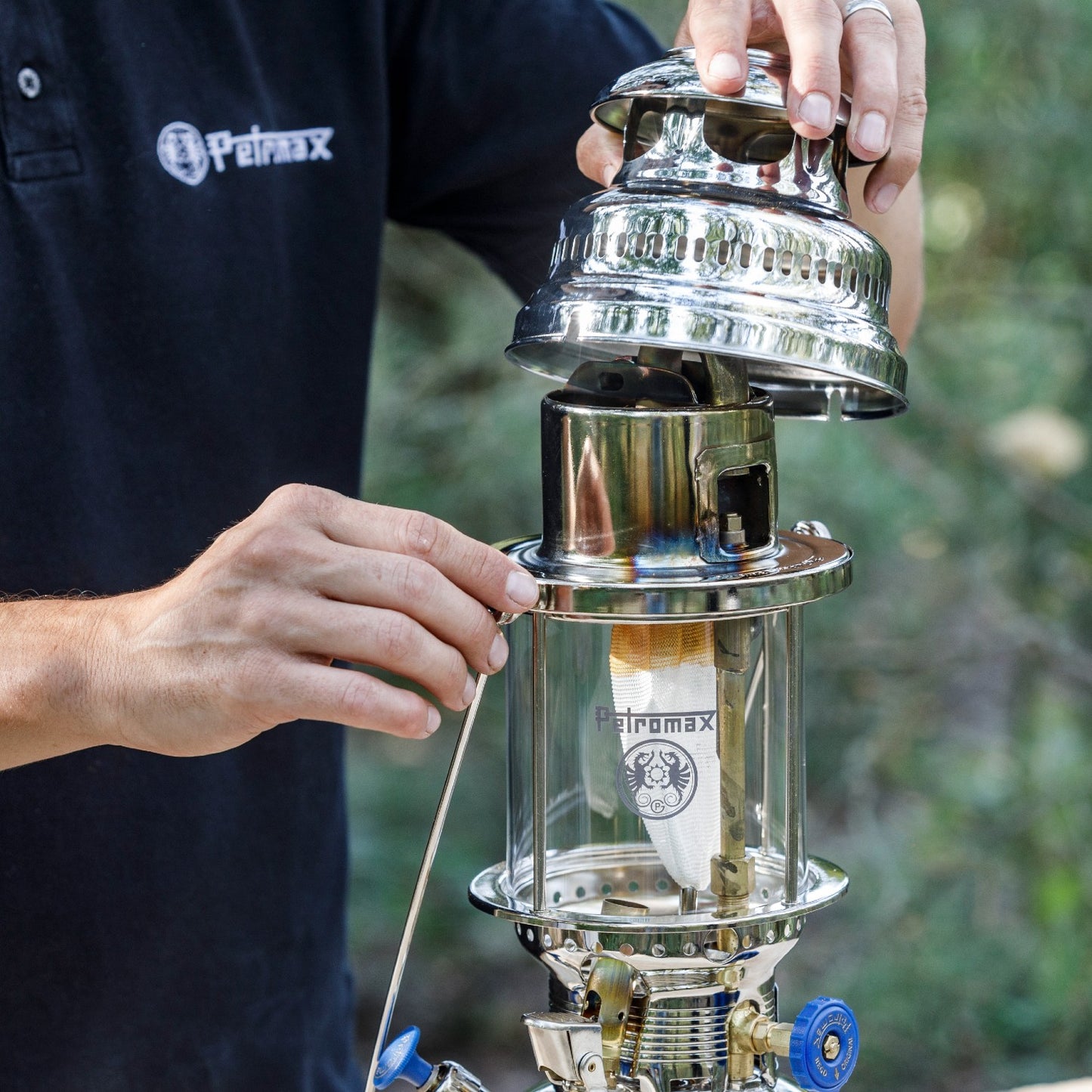 Person assembling a polished brass and chrome Petromax lamp hood with ventilation holes onto a vintage-style lantern, featured in Lamps & Lighting, Parts and Accessories, Best Sellers, and Promo Eligible collections.