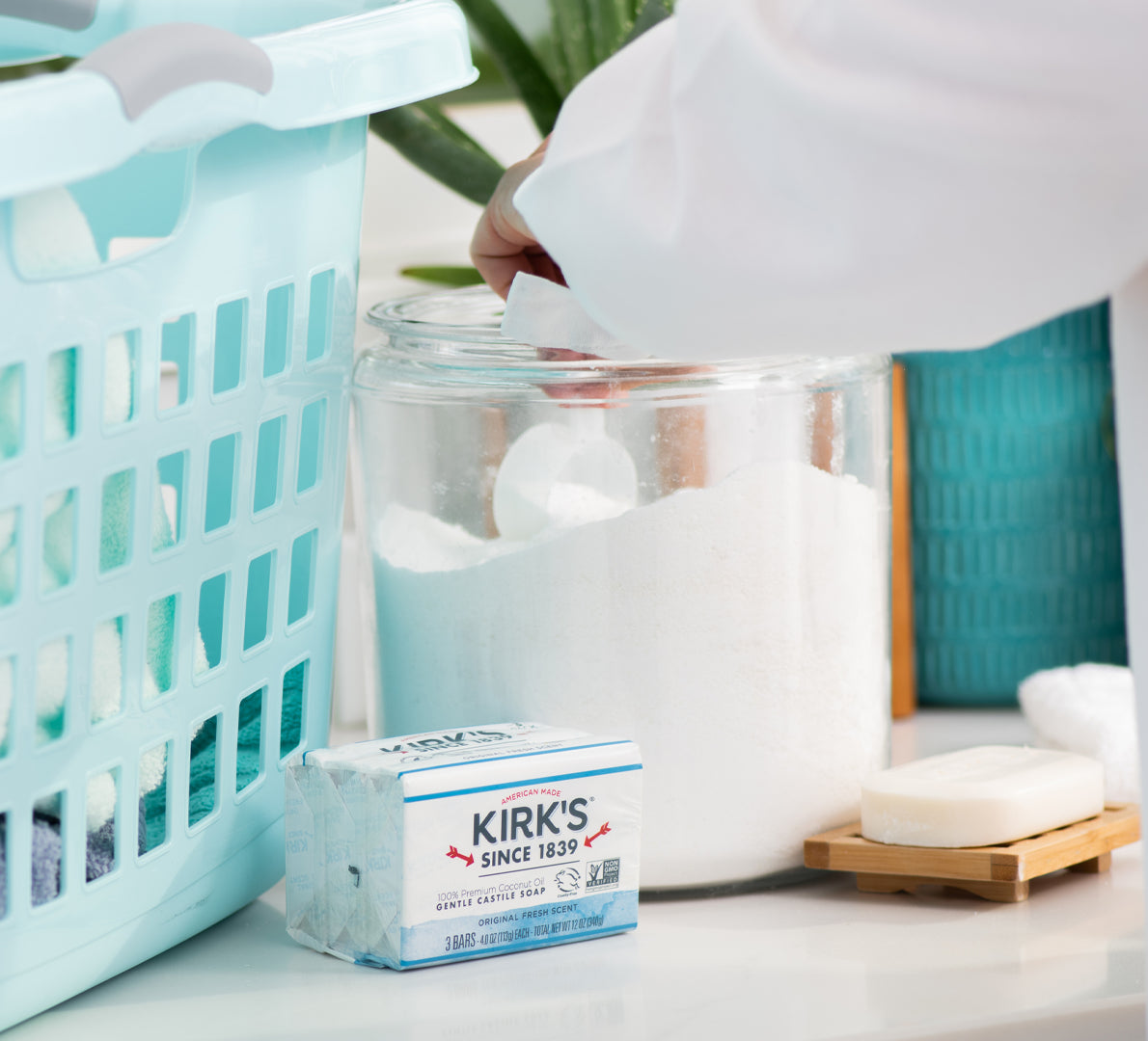 Handcrafted bar of Original Kirk's Castile Soap with gentle formula made in USA, placed near laundry basket and jar of detergent powder, ideal for Health & Wellness and Grooming collections.