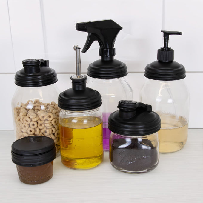 Set of seven eco-friendly, reusable black reCAP lids in various styles including pump, spray, pour spout, and screw top on glass jars, handcrafted in the USA for Home & Decor, Household Helpers, and Best Sellers collections.