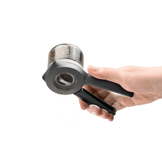 Hand holding a black and clear adjustable spice mill grinding fresh peppercorns, designed for easy one- or two-handed use, featured in Kitchen & Food, Dinnerware, and Kitchen Gadgets collections.