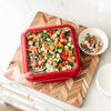 Red travel cover designed for 8x8 foil pans protecting a fresh vegetable and rice salad, shown on a wood-patterned serving board in Kitchen & Food, Kitchen Accessories, USA Made collections.