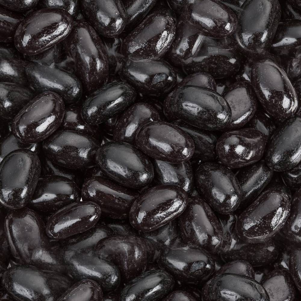 Close-up view of glossy jumbo black licorice jelly beans, showcasing their smooth texture and deep black color, featured in Kitchen & Food and Snacks and Sweets collections.