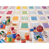Colorful spools of thread scattered on a hand-sewn quilt pattern with sewing accessories, depicting a unique handcrafted design made in USA, featured in Toys, Books & Games and USA Made collections.
