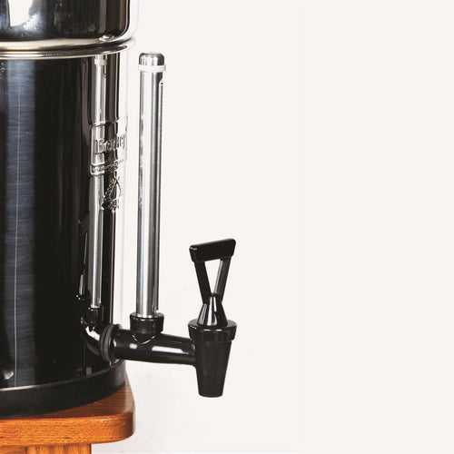 Polished metal water filter with a clear vertical sight glass tube and black plastic spigot, designed for easily monitoring water levels in Berkey water filters for appliances and water treatment.