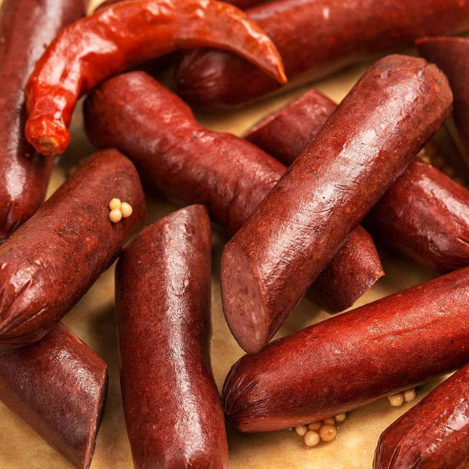 Close-up of rich reddish smoked sausage links, showcasing a handcrafted pickled polish style with a glossy texture, ideal for pantry, kitchen, and USA made food collections.