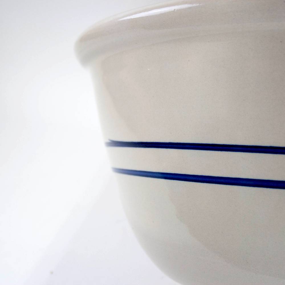 Close-up of a handcrafted stoneware mixing bowl in cream with two deep blue stripes, made in the USA, ideal for Kitchen & Food, Cookware, Baking Supplies, and Storage collections.