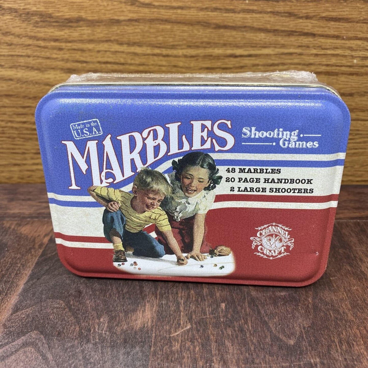 Handcrafted metal tin box featuring vintage artwork of children playing marbles, containing 48 marbles, two large shooters, and a 20-page handbook, made in USA, part of Toys, Books & Games, Children's Toys, Games and Puzzles, Table and Board Games, Best Sellers, and Promo Eligible collections.