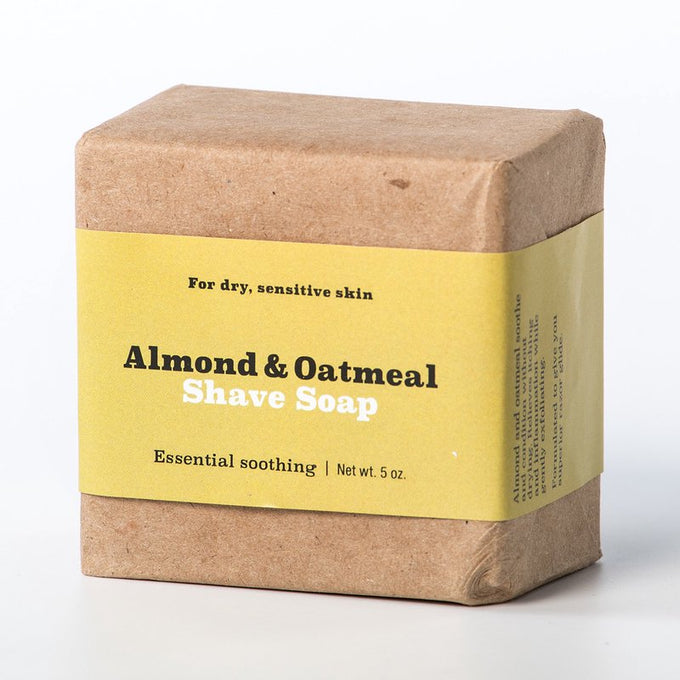 Natural almond and oatmeal shaving soap bar wrapped in brown paper with yellow label, handcrafted for soothing sensitive skin, ideal for Health & Wellness and USA Made collections
