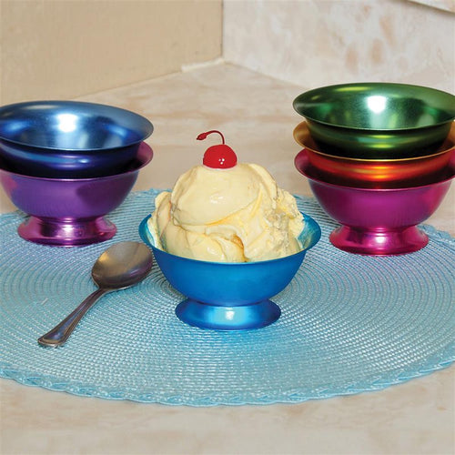 Assorted set of six handcrafted aluminum bowls in blue, bright blue, green, gold, pink, and purple, shown with ice cream and a spoon on a blue placemat, featured in Kitchen & Food and Dinnerware collections.