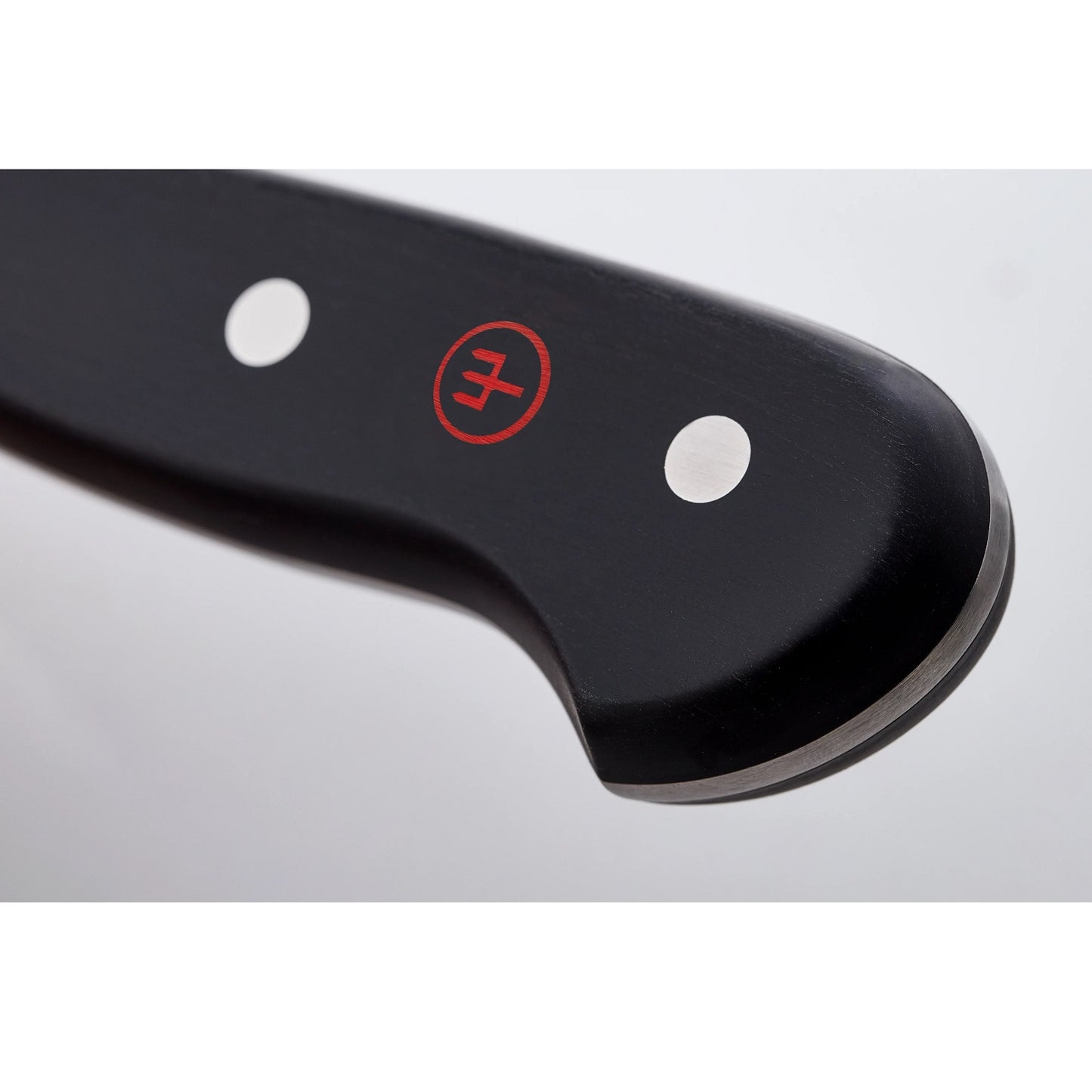 Close-up of a black handle with two metal rivets and a red logo on a premium chef’s knife, highlighting its sturdy full tang design for kitchen and food prep use.