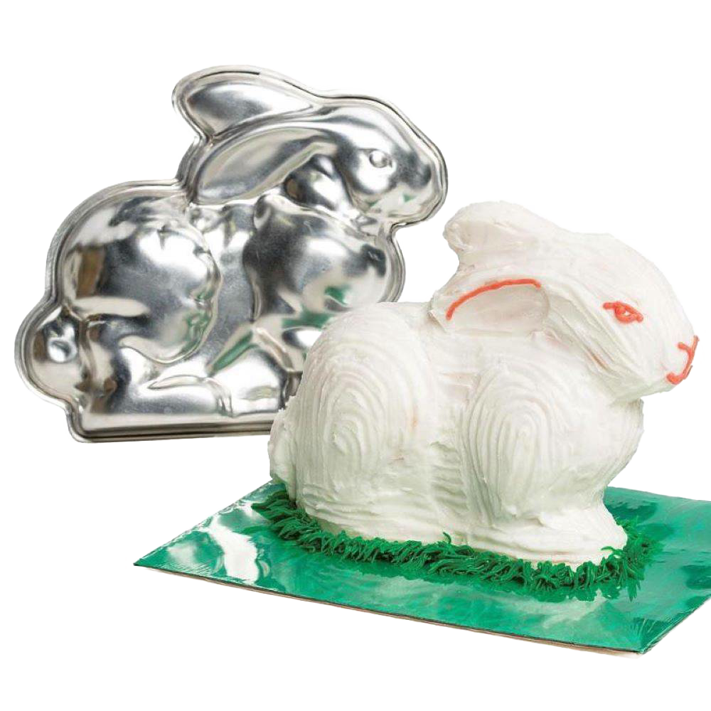 Handcrafted metal bunny cake pan next to a decorated 3D bunny cake with white frosting and green grass detail, featured in Kitchen & Food, Cookware, Baking Supplies, USA Made collections.