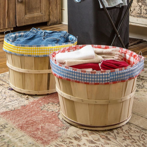 Two handcrafted bushel baskets lined with gingham-patterned reusable liners in a cozy laundry room, part of Home & Decor and Laundry Supplies collections.