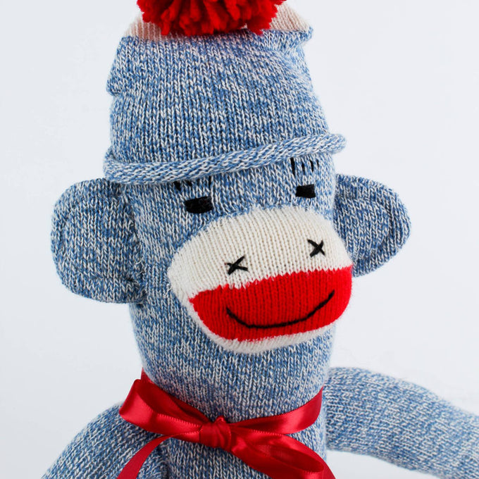 Hand-sewn blue knit monkey with red pom-pom hat and red ribbon bow, handcrafted in the USA, featured in Toys, Books & Games, USA Made, Children's Toys, Indoor Play, and Best Sellers collections.