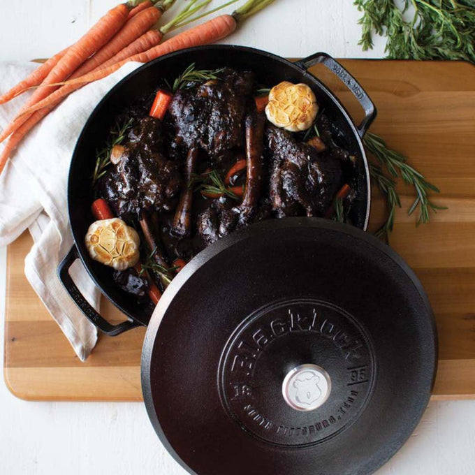 Lodge Blacklock cast iron braiser with lid, featuring a secure fit and triple-seasoned surface, filled with slow-cooked meat and vegetables, handcrafted and made in USA, ideal for Kitchen & Food, Cookware, Cast Iron, and USA Made collections.