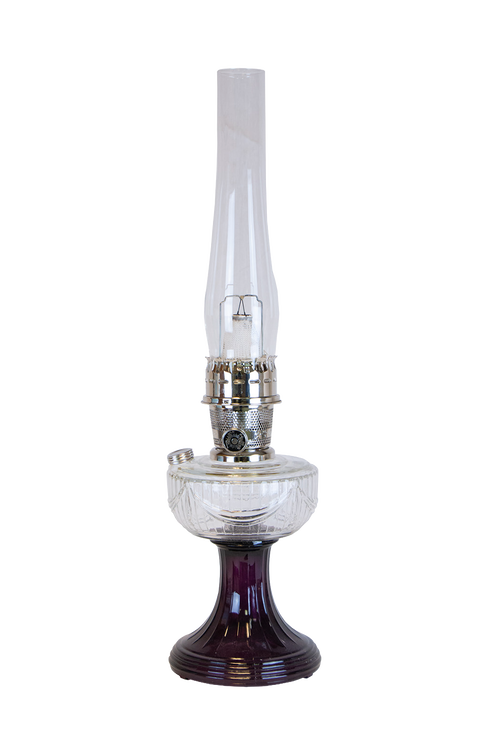 Handcrafted oil lamp featuring a clear glass font resting on an amethyst glass pedestal base with a polished metal burner and tall chimney, ideal for Lamps & Lighting and Best Sellers collections.