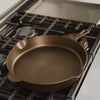 Handcrafted lightweight cast iron skillet with a smooth cooking surface and dual pour spouts, resting on a gas stove, perfect for Kitchen & Food, Cast Iron, USA Made, and Camping collections.