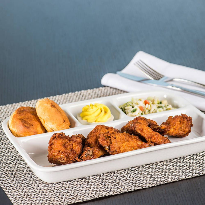 Porcelain divided tray set with crispy fried chicken, two golden biscuits, mustard condiment, and a side of coleslaw, styled on woven placemat for Kitchen & Food and Dinnerware collections.