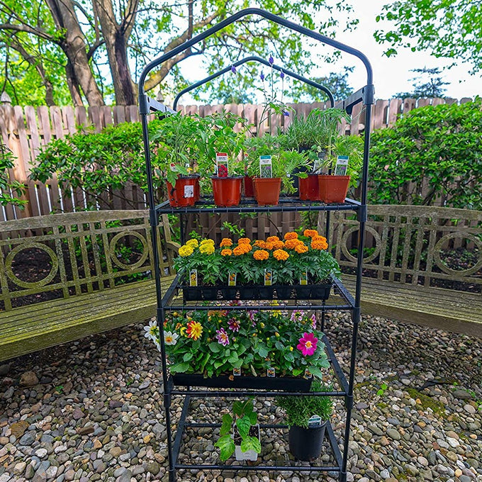 Compact greenhouse with four wire grid shelves holding various potted plants and flowers, ideal for small spaces and promoting air circulation, featured in Farm, Garden & Tool and Garden Accessories collections.