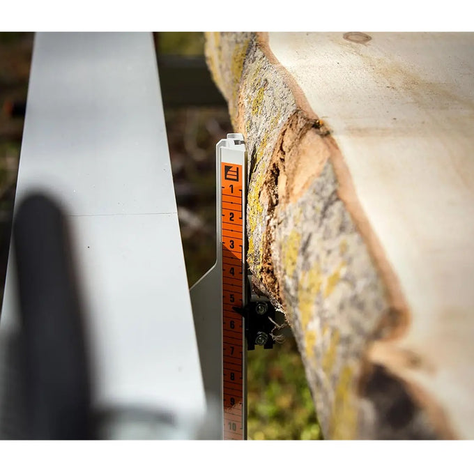 Close-up of a measurement scale on a portable metal lumber sawmill cutting a large log, highlighting precision craftsmanship for Farm, Garden & Tool, Wood Cutting and Hauling, and Best Sellers collections.