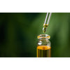 Close-up of a glass dropper releasing golden herbal extract into a small clear bottle, symbolizing natural wellness and immune support in health and wellness books collection.