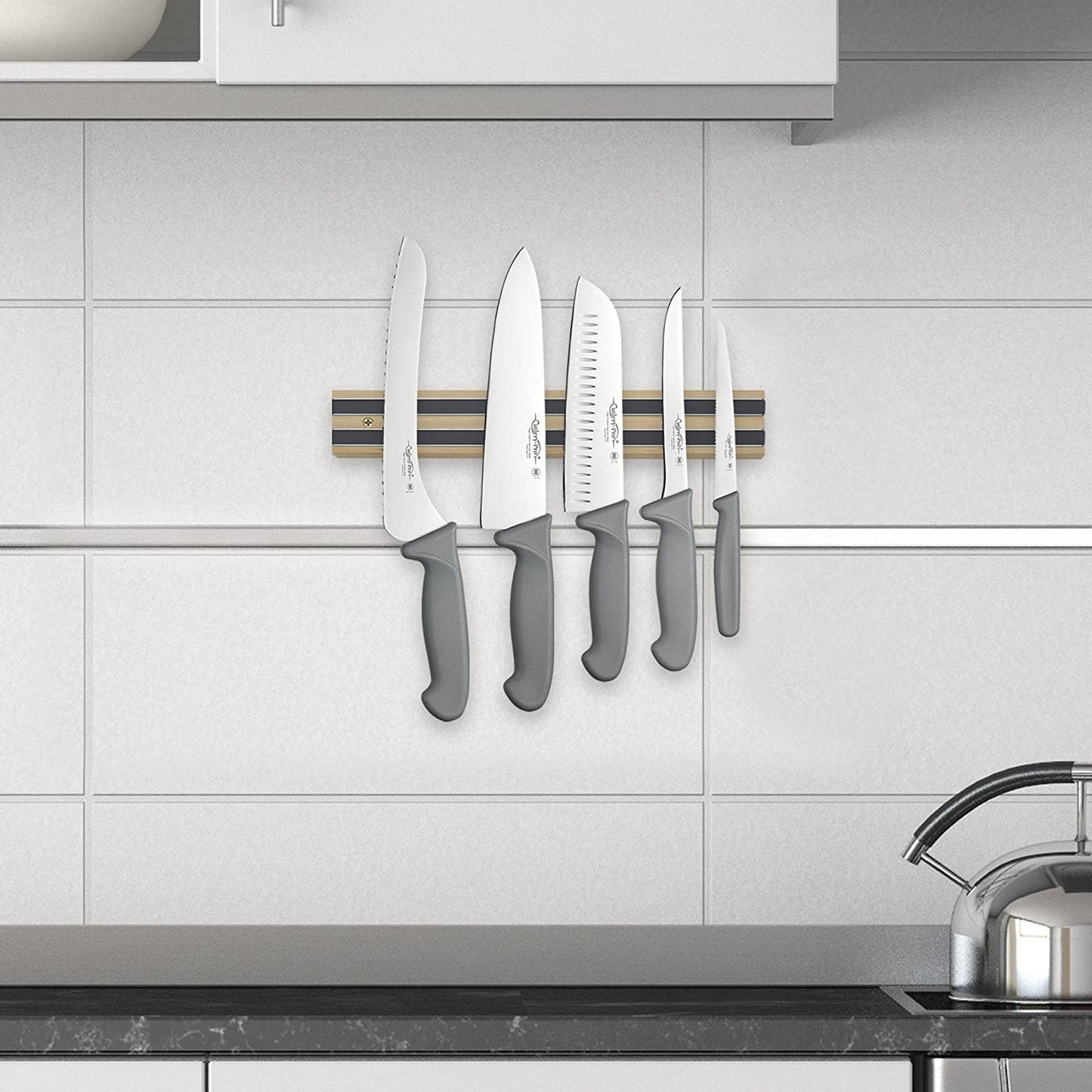 Heavy duty hardwood magnetic knife holder mounted on tiled kitchen wall, securing five knives with gray handles, perfect for organizing in Farm, Garden & Tool, Kitchen & Food, and Knives & Axes collections.