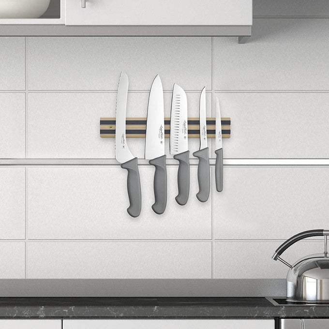 Heavy duty hardwood magnetic knife holder mounted on tiled kitchen wall, securing five knives with gray handles, perfect for organizing in Farm, Garden & Tool, Kitchen & Food, and Knives & Axes collections.