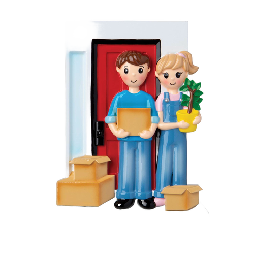 Handcrafted resin ornament of a smiling couple in casual clothes standing in front of a red door with moving boxes and a small green plant, part of Home & Decor and Holiday Decor collections.