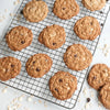 Freshly baked oatmeal chocolate chip cookies cooling on a durable oven-safe grid with an embossed pattern, ideal for Kitchen & Food, Baking Supplies, and USA Made collections.