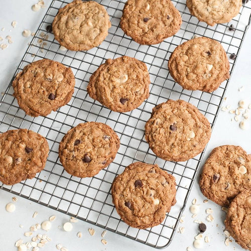 Freshly baked oatmeal chocolate chip cookies cooling on a durable oven-safe grid with an embossed pattern, ideal for Kitchen & Food, Baking Supplies, and USA Made collections.