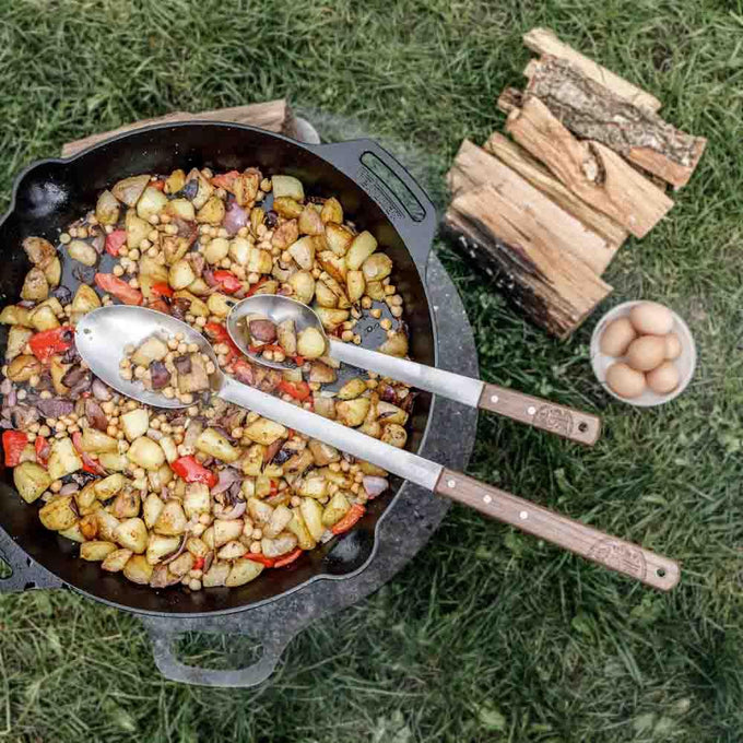 Handcrafted cast iron skillet with two side handles cooking a colorful mix of potatoes, chickpeas, and peppers outdoors, perfect for farm, camping, kitchen, cookware, and cast iron collections.