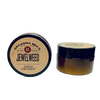 Two small amber glass jars with black lids containing handcrafted jewelweed salve, a natural remedy for itch relief, featured in Health & Wellness and USA Made collections.