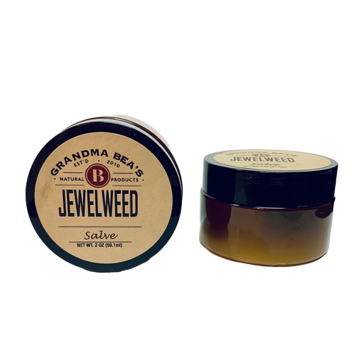 Two small amber glass jars with black lids containing handcrafted jewelweed salve, a natural remedy for itch relief, featured in Health & Wellness and USA Made collections.