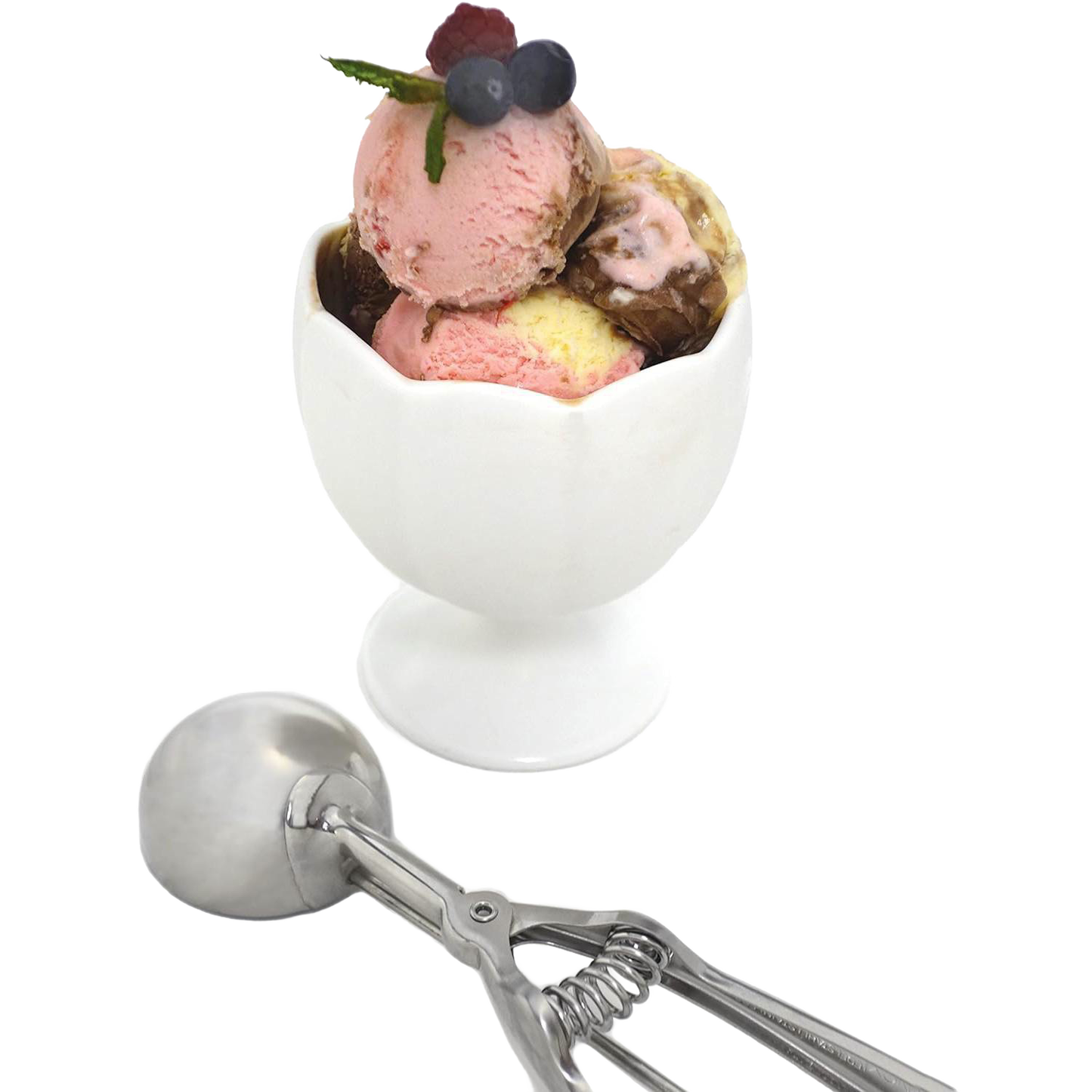 Stainless steel scoop with spring handle resting next to a white ceramic dessert cup filled with three scoops of ice cream garnished with fresh berries, handcrafted for Kitchen & Food, Cookware, Baking Supplies, Kitchen Gadgets, and Best Sellers collections.