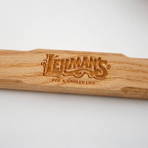 Close-up of a handcrafted wooden handle featuring an engraved Lehman’s logo and tagline, highlighting unique quality in farm, garden & tool and wood cutting collections.