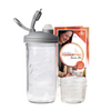 Clear wide-mouth glass jar with a gray fermentation lid and waterless airlock next to a small Mason jar and instructional packaging, ideal for kitchen fermenting and food preservation, USA made.
