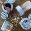 Set of four airtight spice shaker lids for regular-mouth jars with flip tops and shaker inserts, shown with various spices and a wooden spreader, ideal for Kitchen & Food, USA Made, and Cooking Helpers collections.
