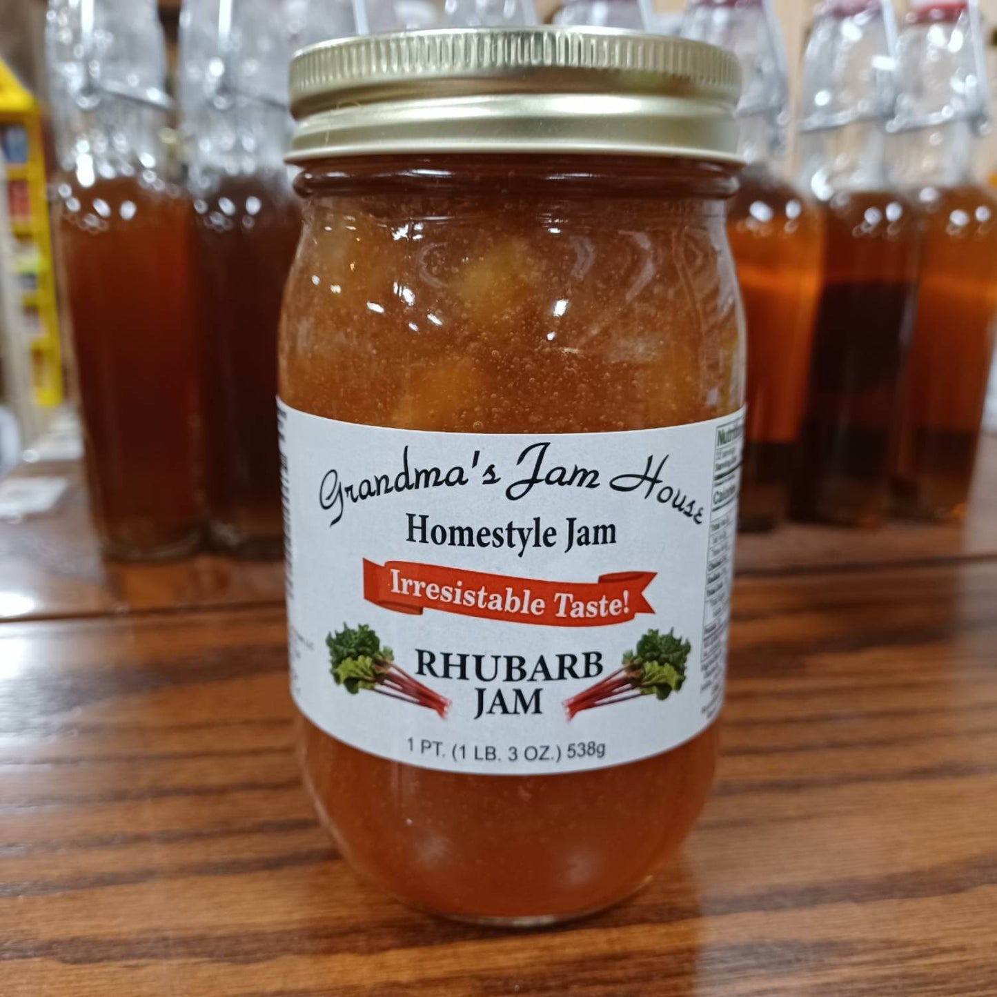 Handcrafted jar of rhubarb homestyle jam with gold lid and white label featuring rhubarb illustrations and "Irresistable Taste" banner, made in USA, ideal for Kitchen & Food, Pantry, Peanut Butter & Jellies, Best Sellers, and Promo Eligible collections.