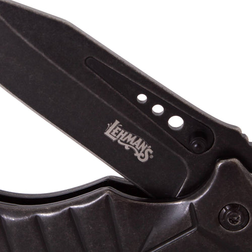 Close-up of a blackened stainless steel pocket knife blade with Lehman's logo, featuring a rugged folding design from the Farm, Garden & Tool and Pocket Knives collections.