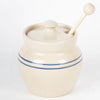 Handcrafted stoneware honey pot in rustic stone color with classic blue stripes and a wooden dipper, part of Kitchen & Food, Storage and Serving, USA Made, and Best Sellers collections.