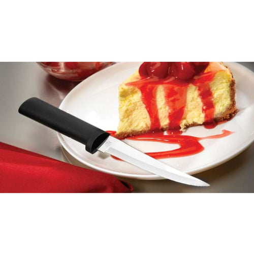 Handcrafted high carbon stainless steel knife with solid black handle resting beside a slice of cheesecake topped with cherry sauce, ideal for kitchen food prep and dessert cutting in USA made collections.