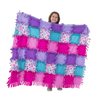 Child holding a large, handcrafted fleece quilt made of colorful purple, pink, teal, and floral patterned squares with tied fringe edges, promoting creativity in children's arts and crafts, toys, and best sellers collections.