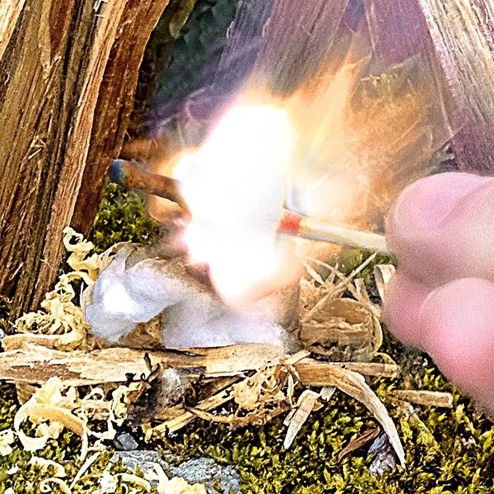 Close-up of a hand striking an outdoor match, igniting a flame on natural tinder with moss and wood, showcasing a handcrafted emergency fire-starting kit ideal for camping and garden supplies.