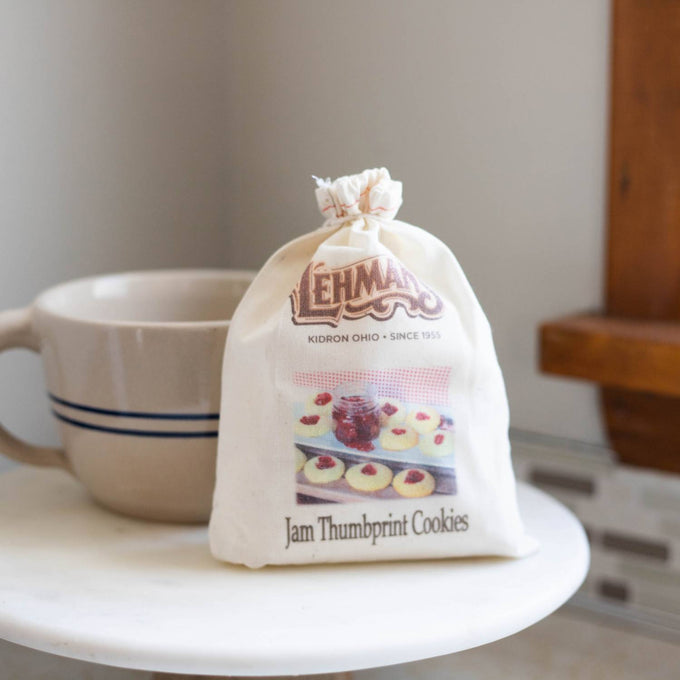 Small cotton drawstring bag of handcrafted Jam Thumbprint cookie mix with vintage-style label, placed on a marble surface near a ceramic mug, perfect for Kitchen & Food, Pantry, Dry Goods and Mixes, Best Sellers, Promo Eligible collections.