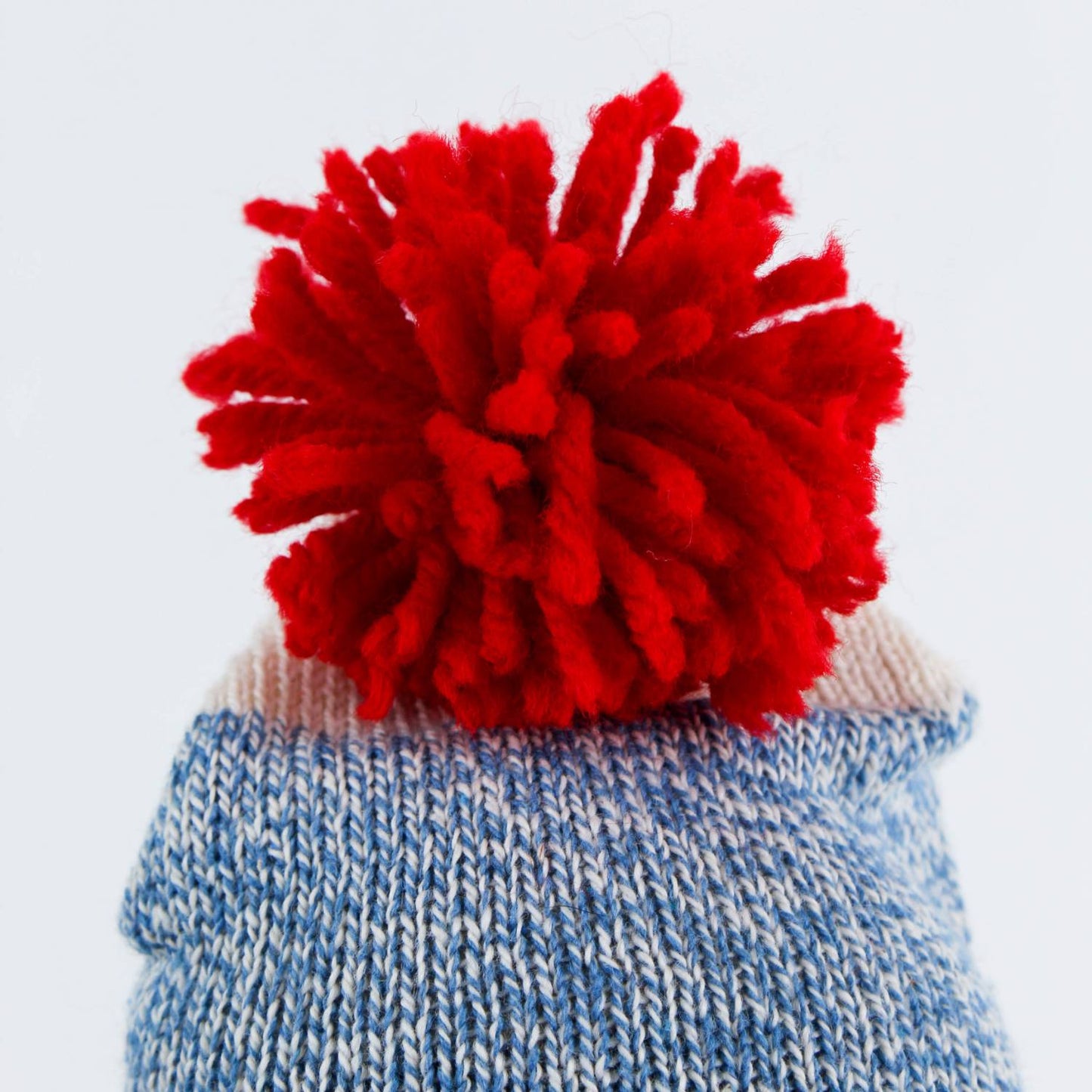 Close-up of a hand-sewn blue knit hat topped with a bright red pom-pom, handcrafted in the USA, featured in Toys, Books & Games, USA Made, Children's Toys, Indoor Play, and Best Sellers collections.